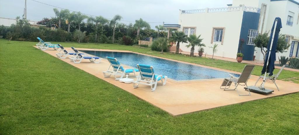una vista sul tetto di una piscina con sedie e una piscina di Ferme d'hôtes de luxe a Skhirat
