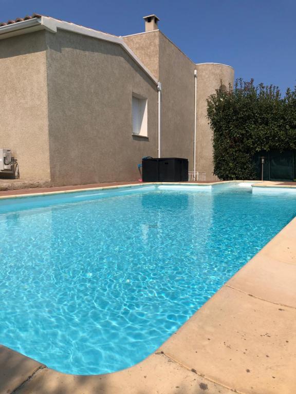 une grande piscine bleue devant une maison dans l'établissement Villa Stagnale, à Aléria