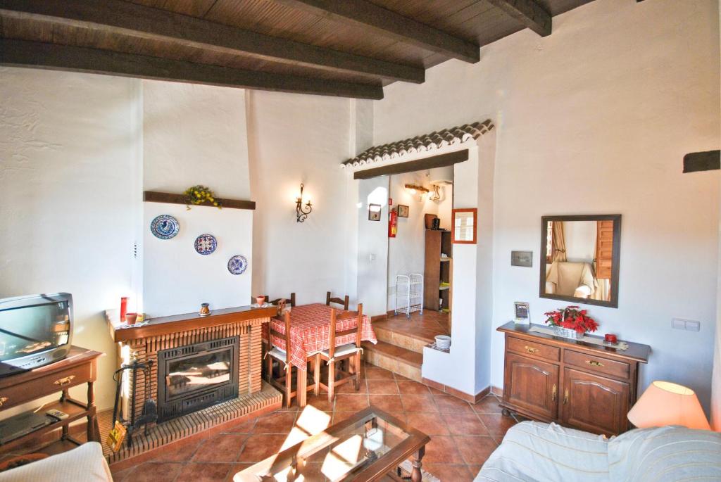 sala de estar con sofá y chimenea en Cortijo Las Monjas, en Periana