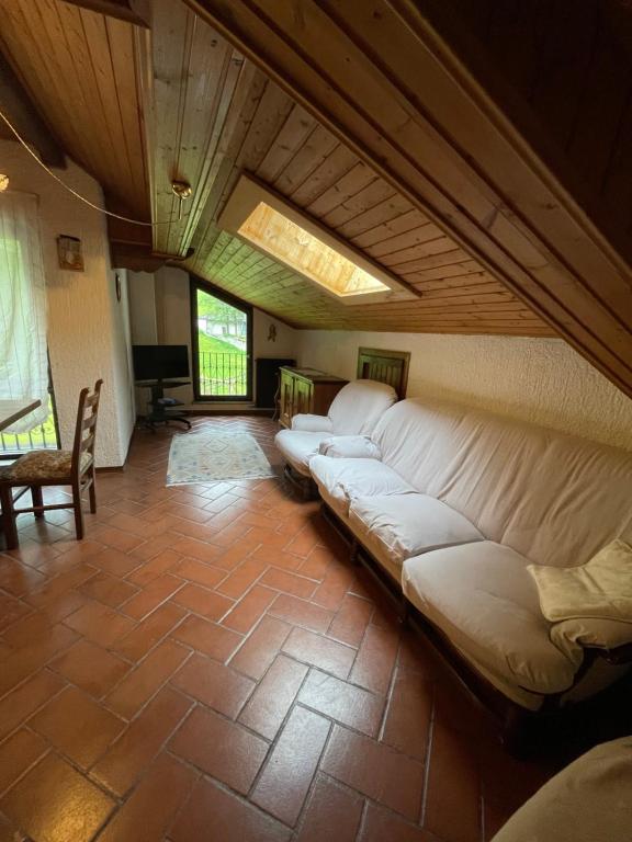 uma sala de estar com um grande sofá branco num quarto em Appartamento Lost em Ceresè