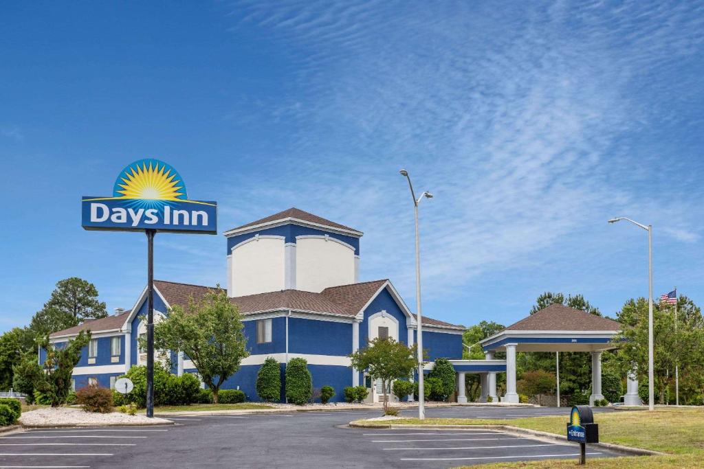 a view of a days inn sign in front of a building at Days Inn by Wyndham Louisburg in Louisburg