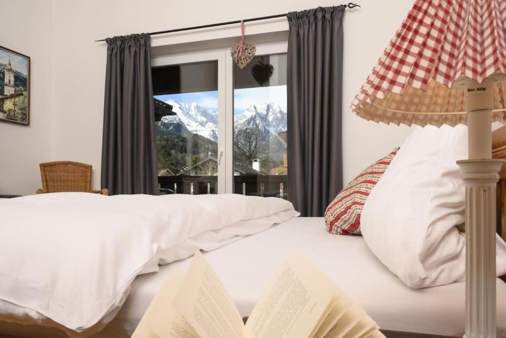 um quarto com uma cama branca e uma janela em Ferienhaus Windschäufeln in Garmisch-Partenkirchen em Garmisch-Partenkirchen