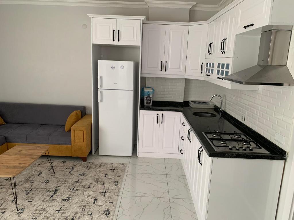 a kitchen with white cabinets and a white refrigerator at Z&A kılıç apart otel in Dargeçit