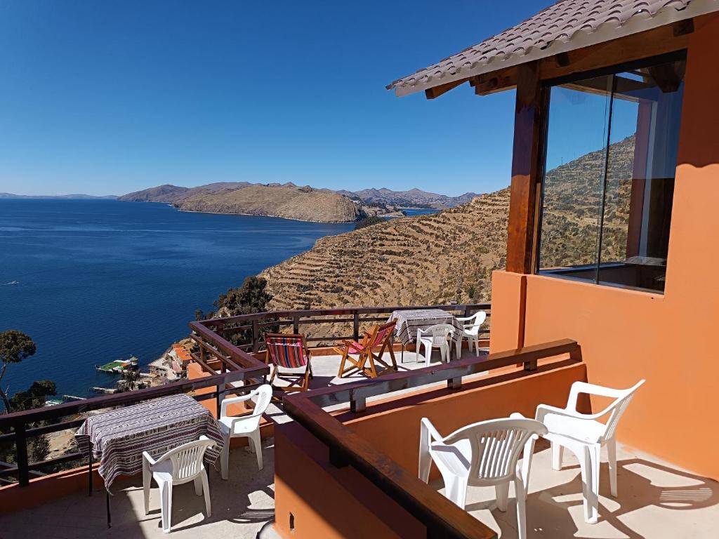 a balcony with chairs and a view of the water at Sol y Luna ISLA DEL SOL in Comunidad Yumani