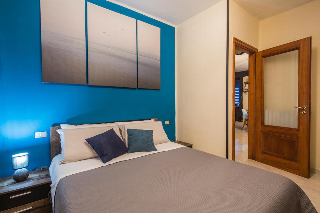una camera con un grande letto con una parete blu di Il Borgo degli Artisti a Montoro Inferiore