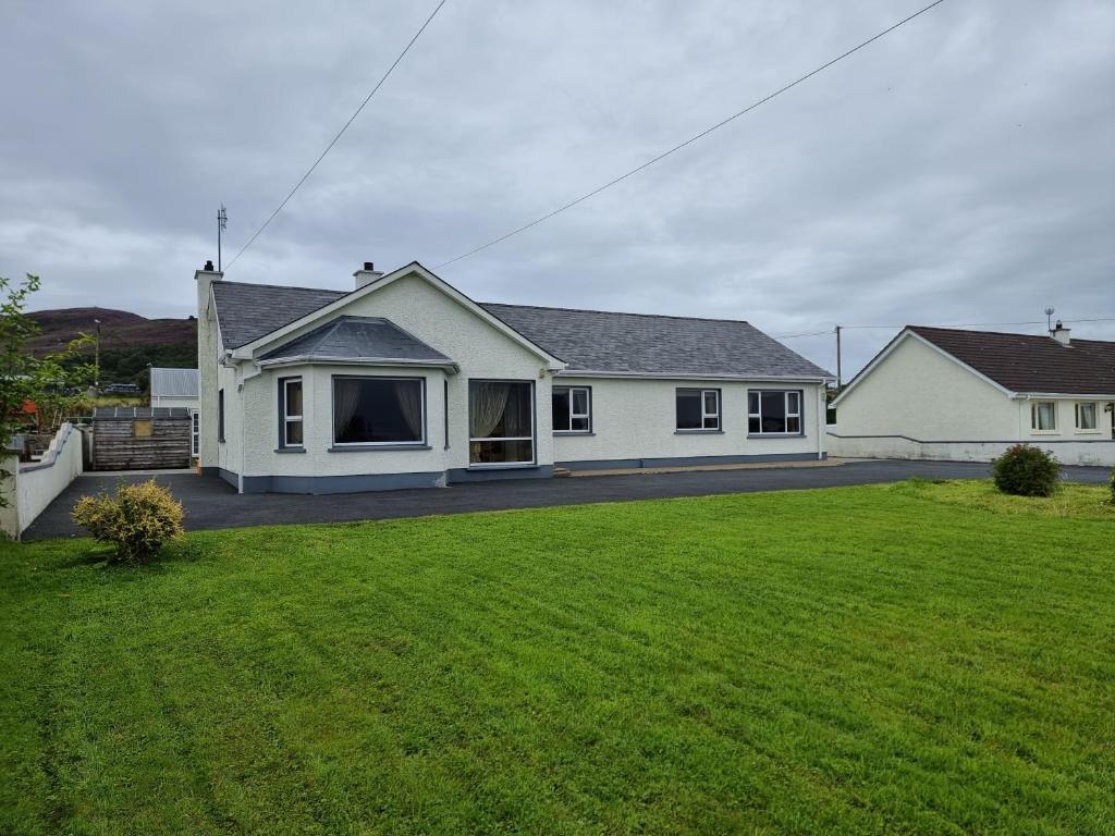 una casa con un gran césped delante de ella en Elemey House en Buncrana