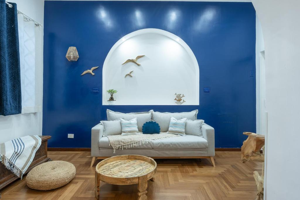ein Wohnzimmer mit blauen Wänden und einem weißen Sofa in der Unterkunft MareLuna Apartment in Neapel