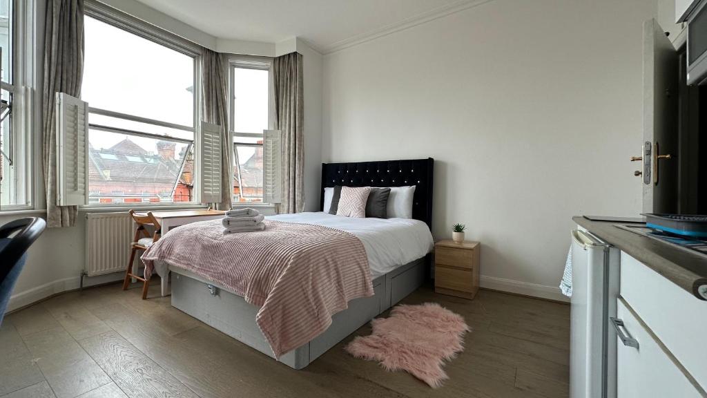 um quarto com uma cama e uma grande janela em Great Studio Sheperds Bush em Londres