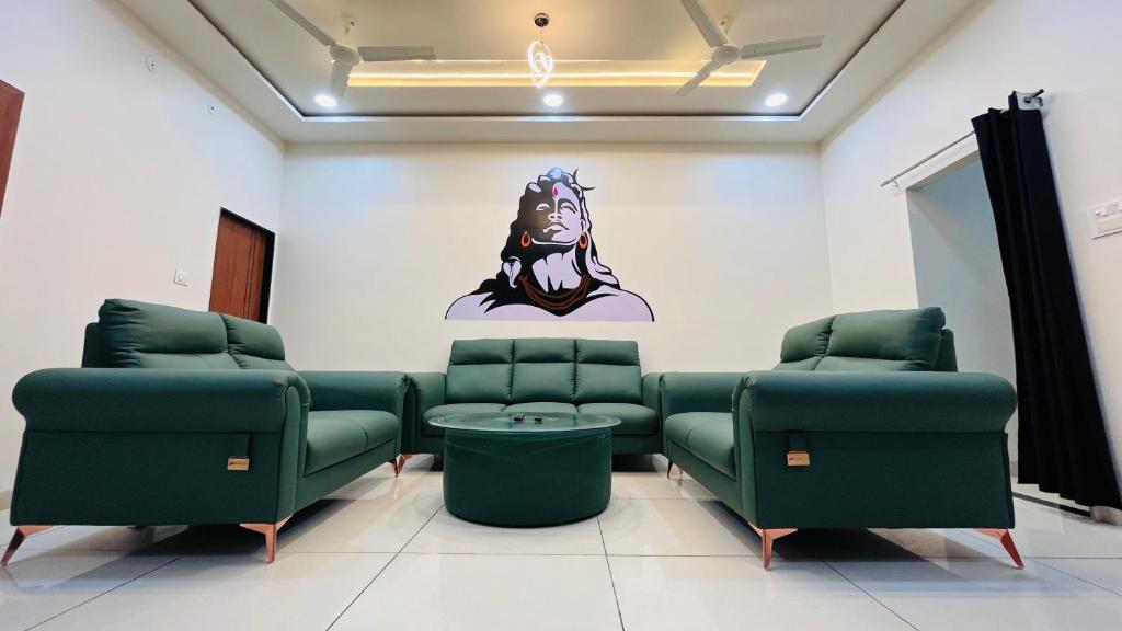 a waiting room with green chairs and a sticker on the wall at Home Escape Luxé Private Villa- Indralaya in Ujjain