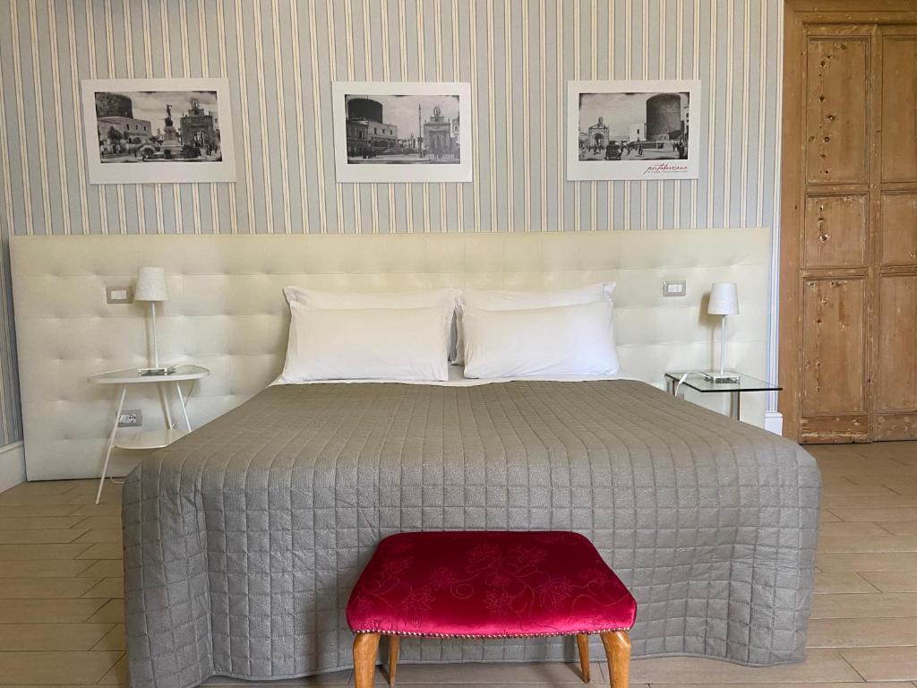 a bedroom with a large bed with a red stool at B&B Porta Baresana in Bitonto