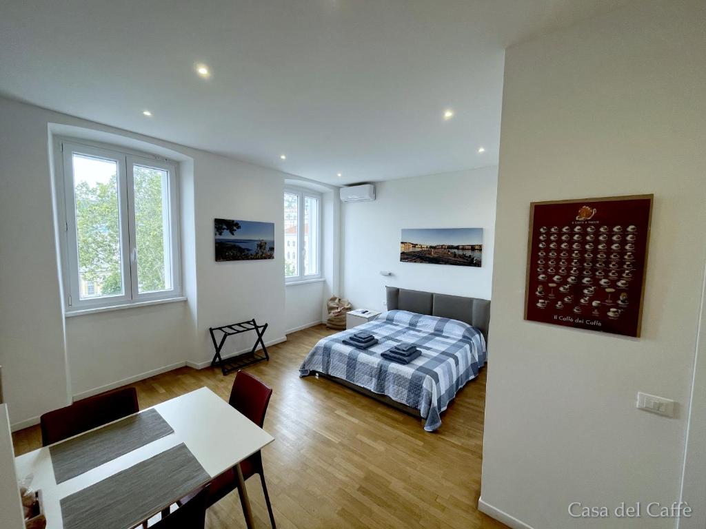 a bedroom with a bed and a table in it at Casa del Caffè in Trieste