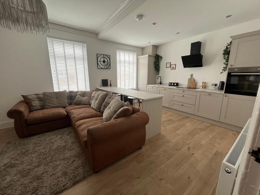 a living room with a couch and a kitchen at Coastal Apartments No 2 in Seaham