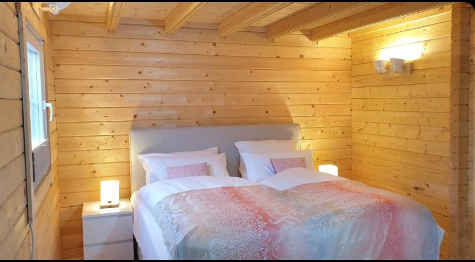 a bedroom with a bed in a wooden room at Ferienhäuser Altes Land in Jork