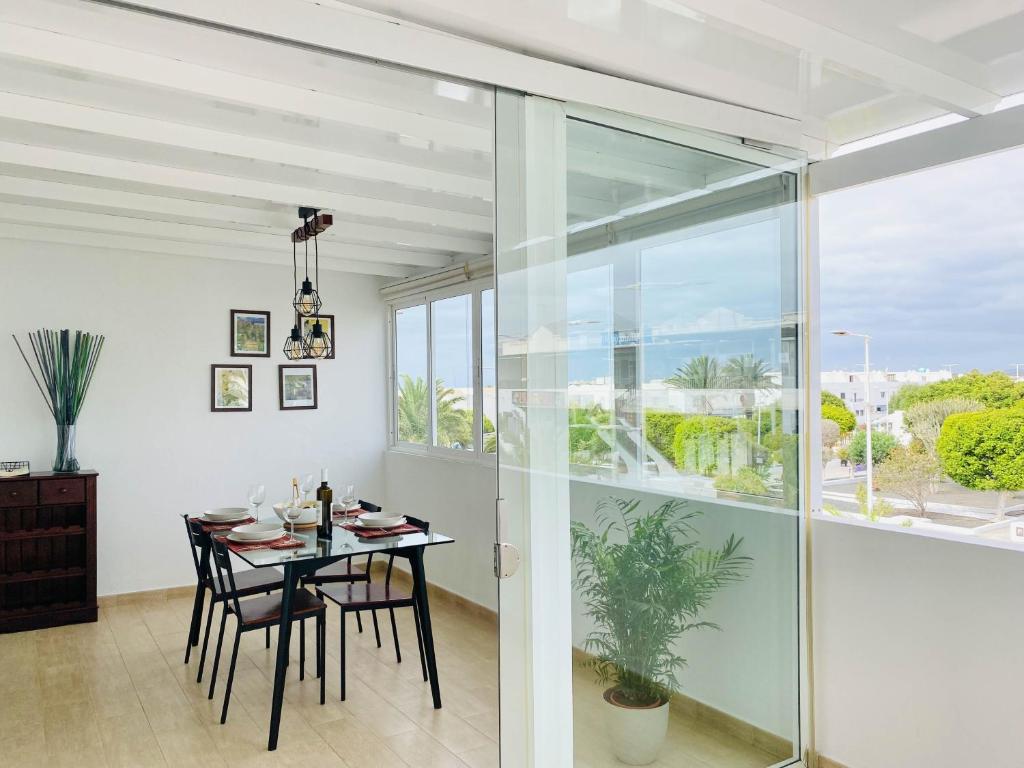 a dining room with a table and a large window at Casa del Mayor in Playa Honda