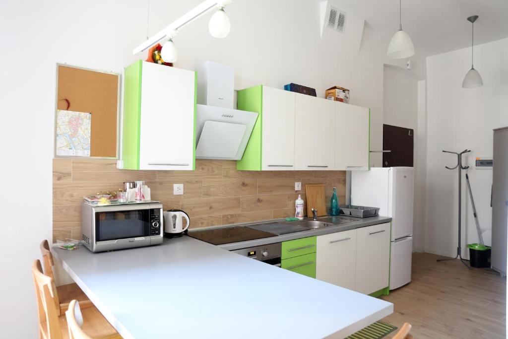 una cocina con armarios verdes y blancos y una encimera en Urocze i ciche mieszkanie w spokojnej okolicy en Cracovia