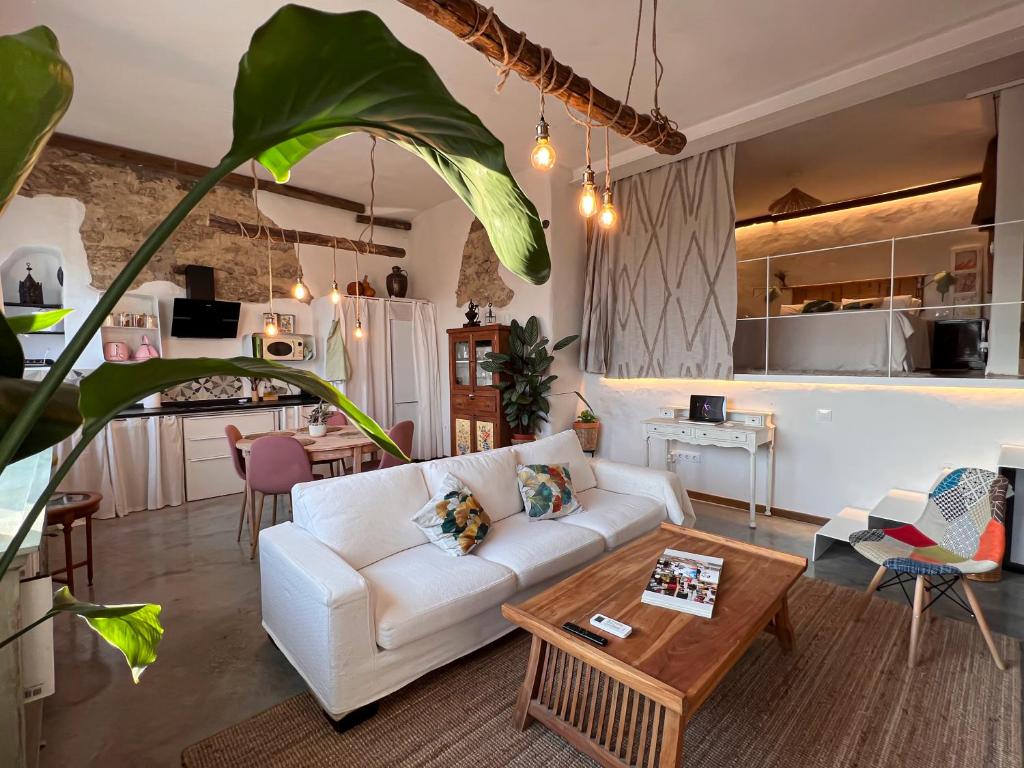 a living room with a white couch and a table at Apartamento Atalantar in Villanueva de la Vera