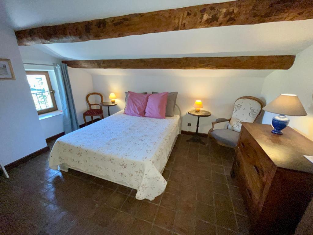 a bedroom with a bed and a table and chairs at Le Mas Saint Jacques in Le Pontet