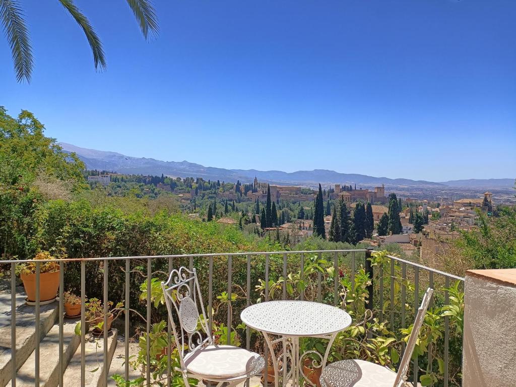 un tavolo e sedie su un balcone con vista di Morente sueña La Alhambra a Granada
