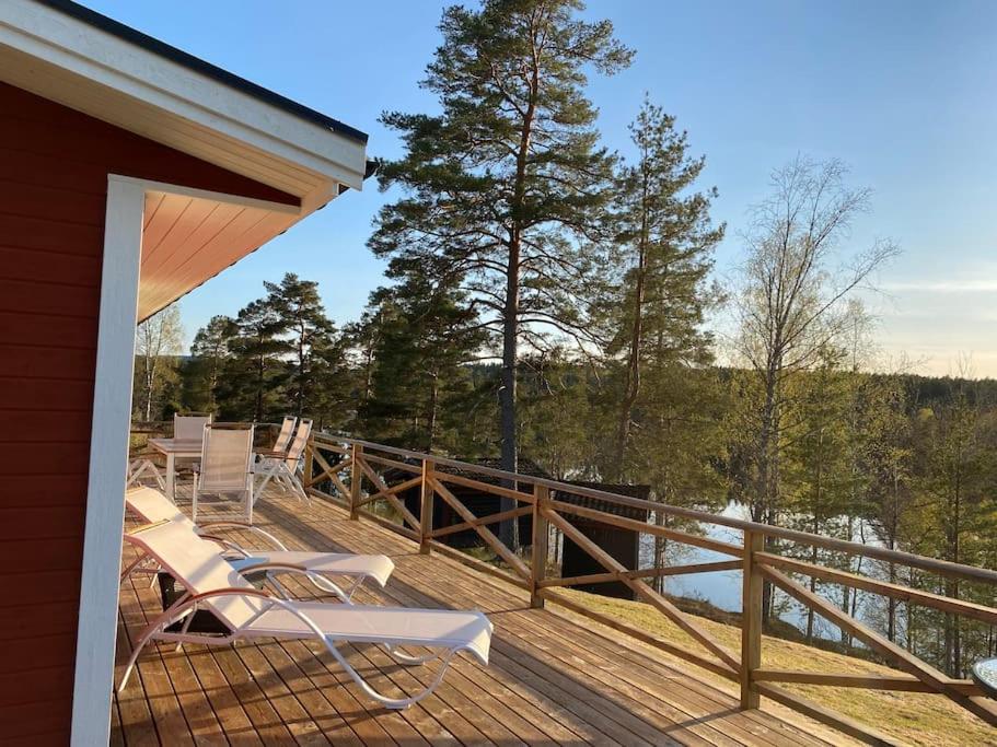 una terraza con sillas y vistas al agua en Trevligt fritidshus med stor terrasse mot sjöen 