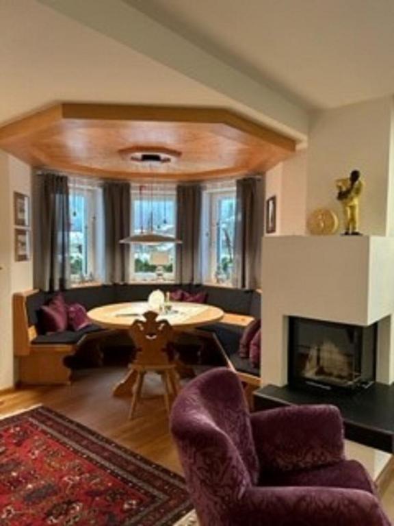 a living room with a table and a fireplace at Grossbergblick in Filzmoos