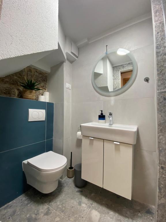 a bathroom with a toilet and a sink and a mirror at House Malena - Rooms in Vis