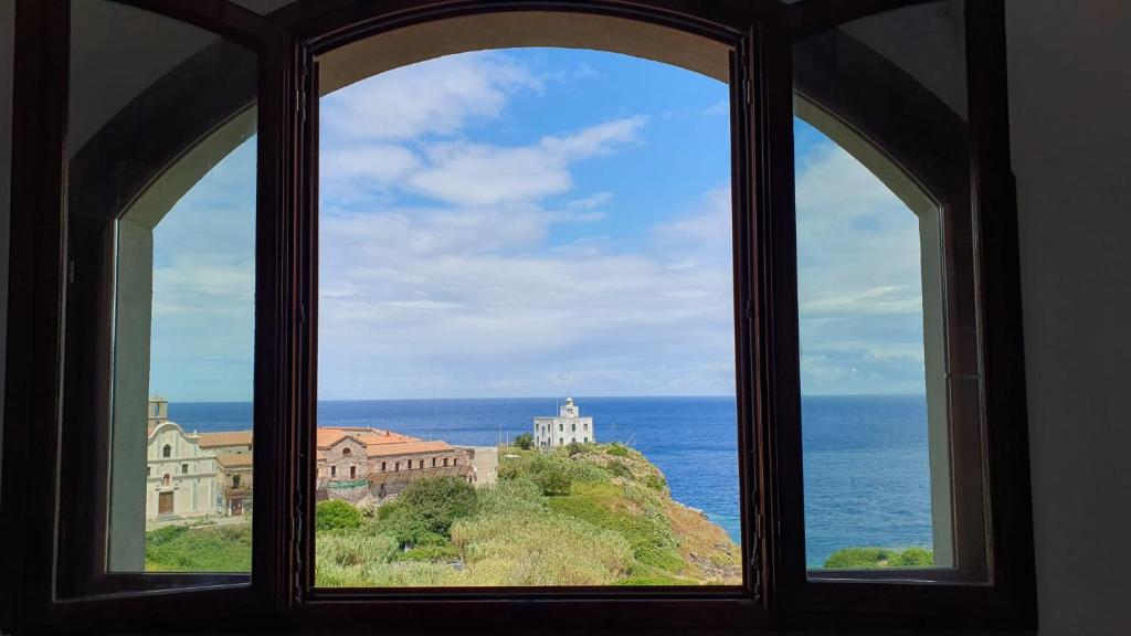 een raam met uitzicht op de oceaan bij Casa Rais Dragut in Capraia