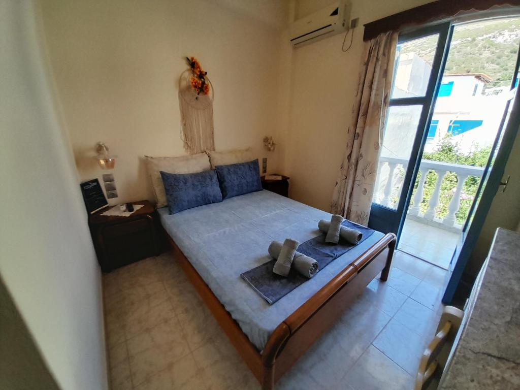 a bedroom with a large bed with blue pillows at Studios IRENE in Fournoi