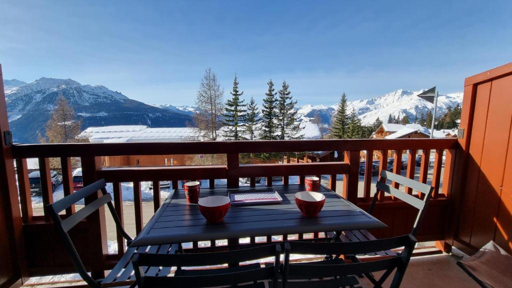 une table sur un balcon avec vue sur les montagnes dans l'établissement Studio 4 personnes à La Rosière, à Montvalezan