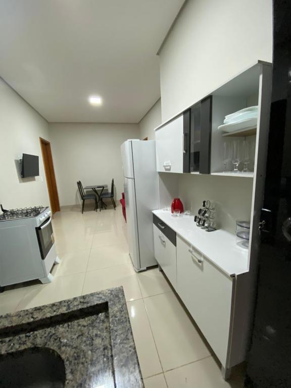 cocina con armarios blancos y nevera en Flat Davisis 3 - PX da JK en Palmas