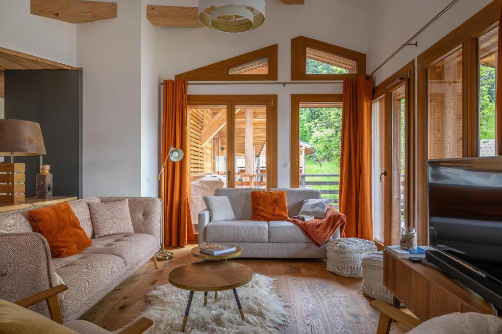 un salon avec un canapé et une télévision dans l'établissement Chalet Les Oréades - Penthouse Duplex Apartment, aux Gets
