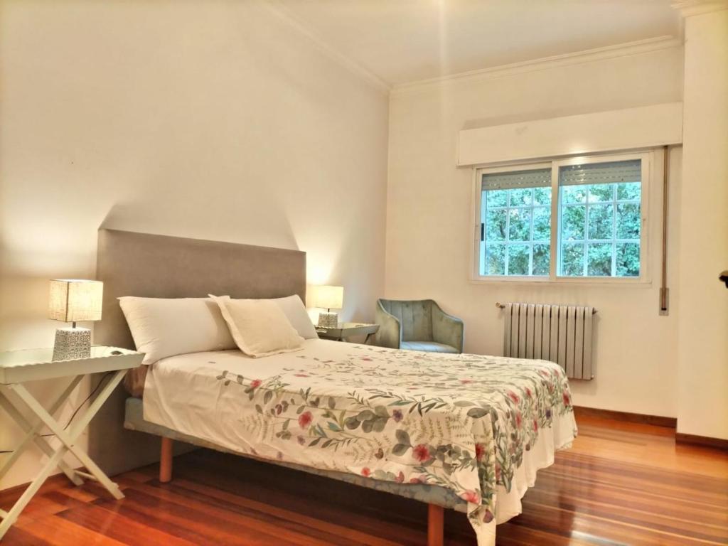 een slaapkamer met een bed, een bureau en een raam bij Oasis Ponte san lázaro in Santiago de Compostela