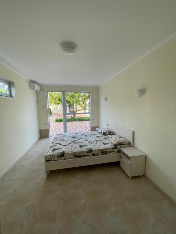 a bedroom with a bed and a large window at Villa Lina in Karolino-Buhaz