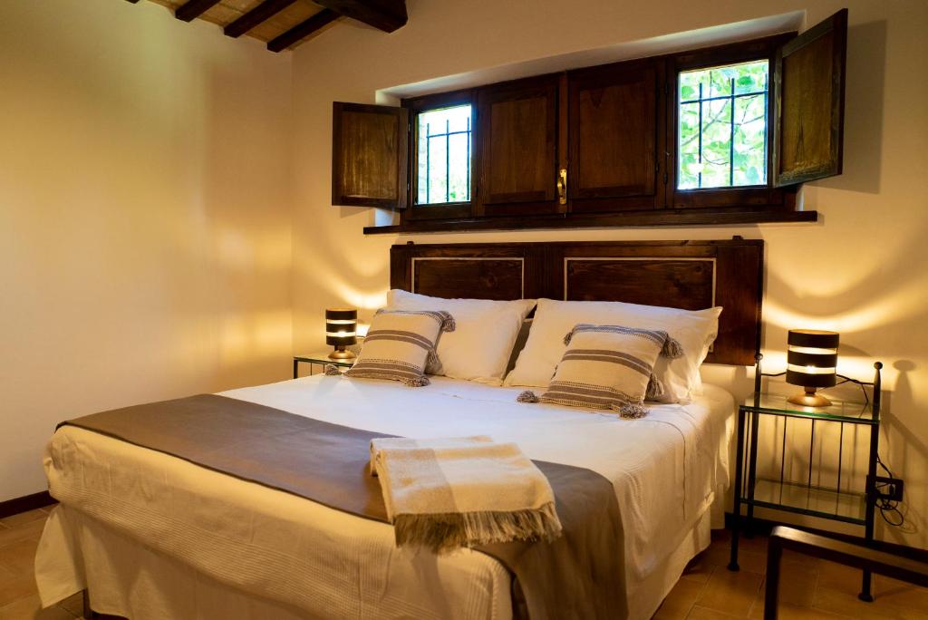 una camera da letto con un grande letto bianco con due finestre di La Capparuccia a Civitanova Marche