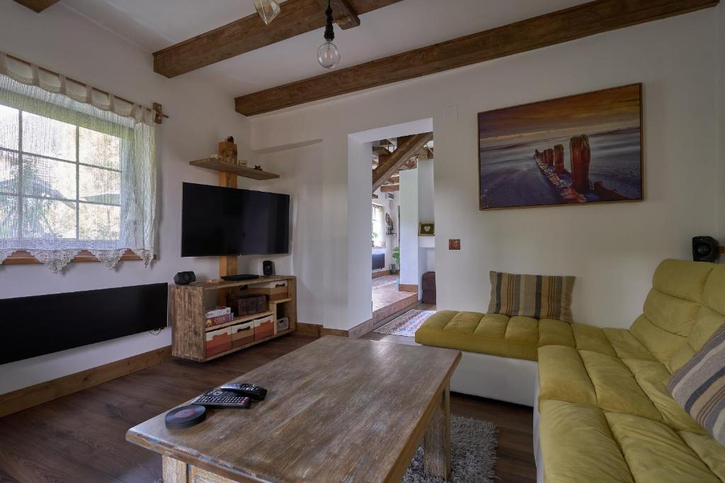un soggiorno con divano e TV di Walnut Tree Cottage a Săcele
