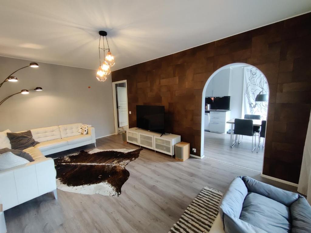 sala de estar con sofá y TV en Freshly renovated apartment, perfect for couple, en Kerava