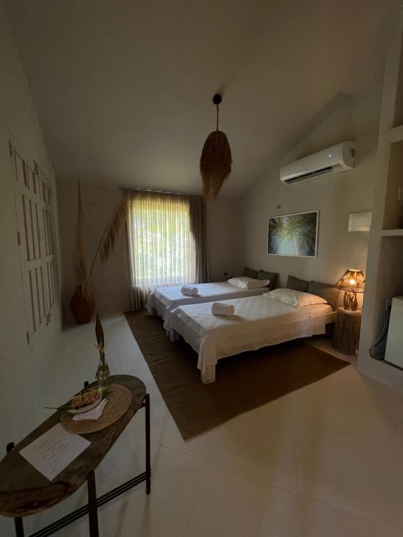um quarto com uma cama grande e uma mesa em KANAHA BEACH VILLA em Icaraí