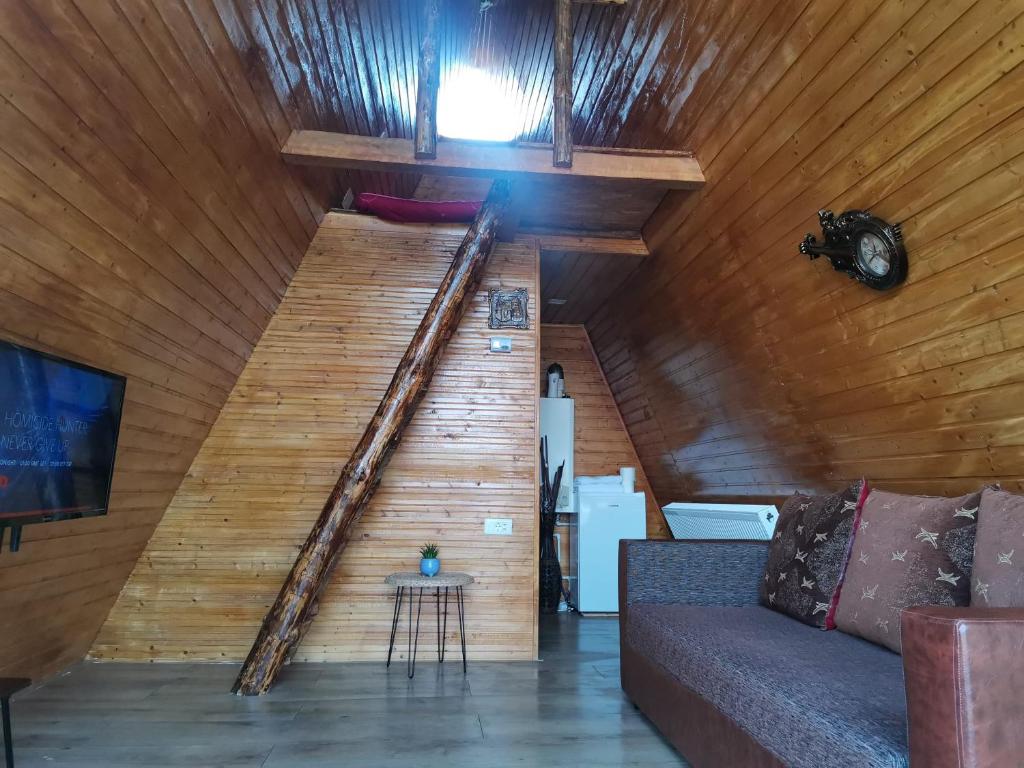 a wooden staircase in a room with a couch at Cabana Ema in Curtea de Argeş