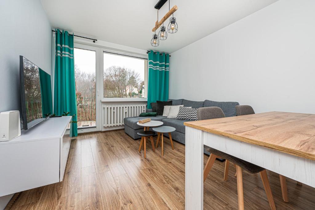 ein Wohnzimmer mit einem Sofa und einem Tisch in der Unterkunft Apartament Octopus Sopot Kamienny Potok in Sopot