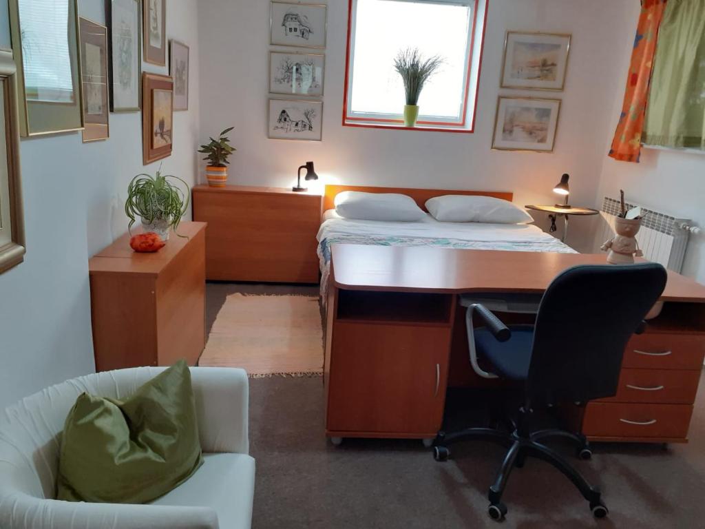 een slaapkamer met een bed, een bureau en een stoel bij Apartman Zdenka Marija in Varaždin