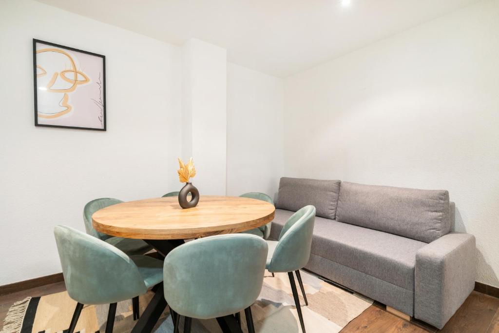 a dining room with a couch and a table and chairs at apartamento en la puerta del sol in Madrid