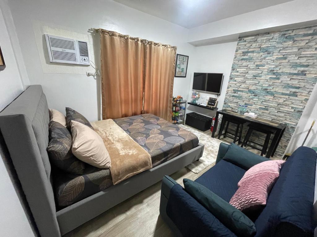 Gravins616 Condo BCD في باكولود: غرفة معيشة مع سرير وأريكة