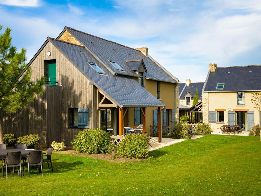 una casa con techo de metal en un patio en Beautiful luxury apartment near a Breton oyster village, en Cancale