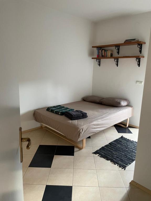 a bedroom with a bed in a room with a tiled floor at Blerta's apartment in Prizren