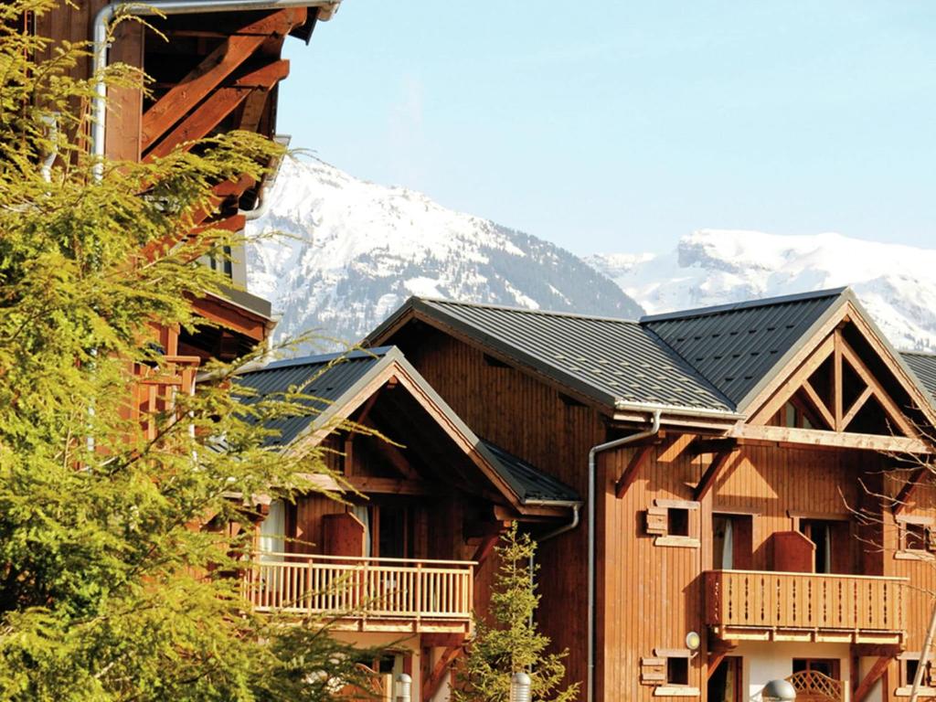 a ski lodge with a mountain in the background at Attractive apartment with a balcony in Le Grand Massif in Samoëns