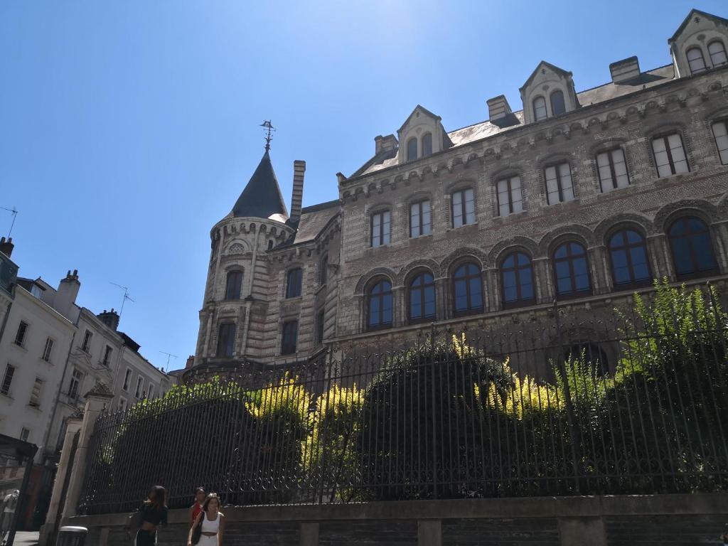 people walking in front of a large building at L'Oisellerie Meublé de Tourisme in Angers