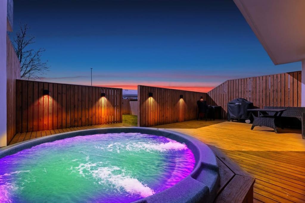 a jacuzzi tub with purple and green water at Venture Vacation-Family Friendly Retreat-HOT TUB in Mosfellsbær