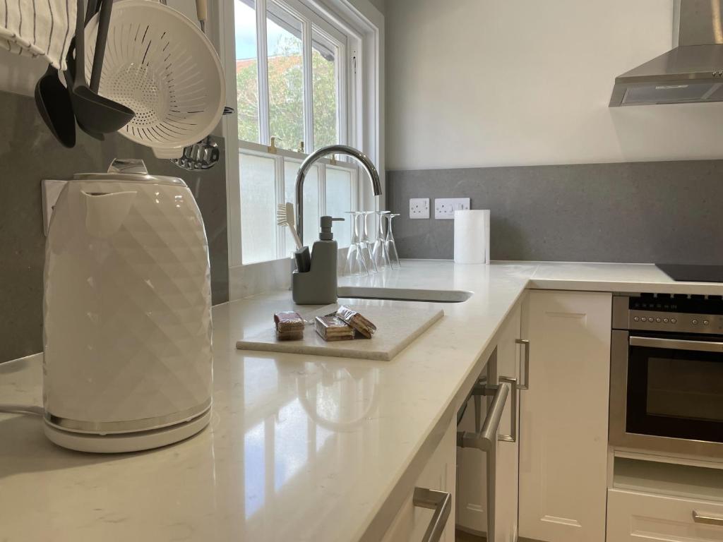 a kitchen with a sink and a mixer on a counter at The Greig 1A in Wadhurst