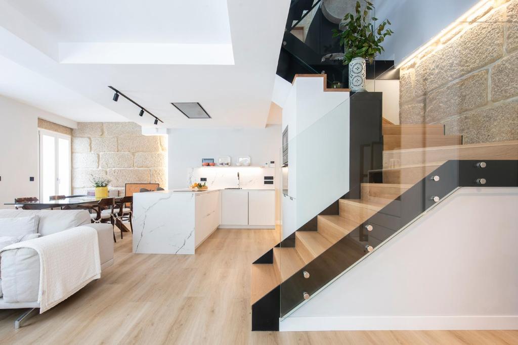 a living room and kitchen with a staircase in a loft at Ronda Don Nacho in Vigo