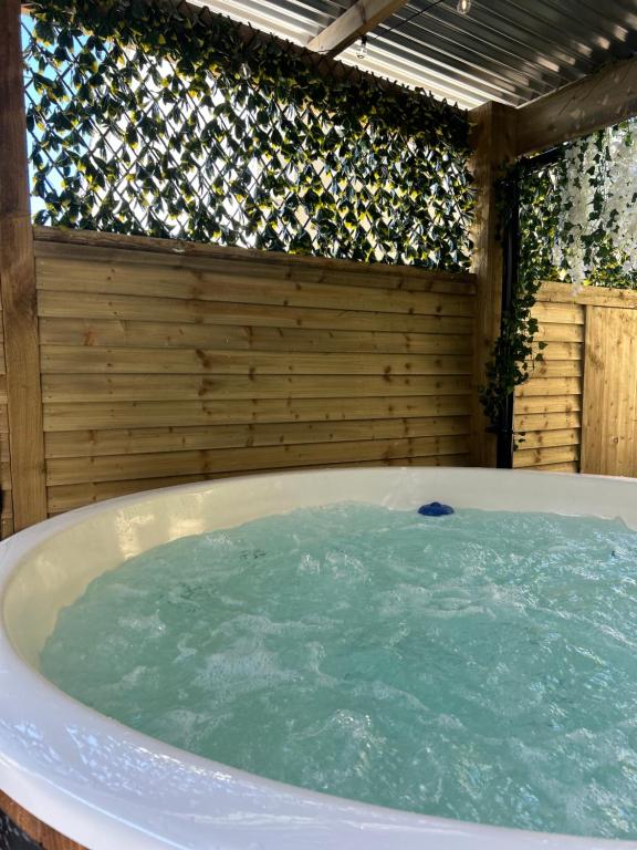 a jacuzzi tub in a backyard with a fence at Sèid Bò - Sleeps 6 - NEW Private 6 Person HotTub Available in Burnfoot