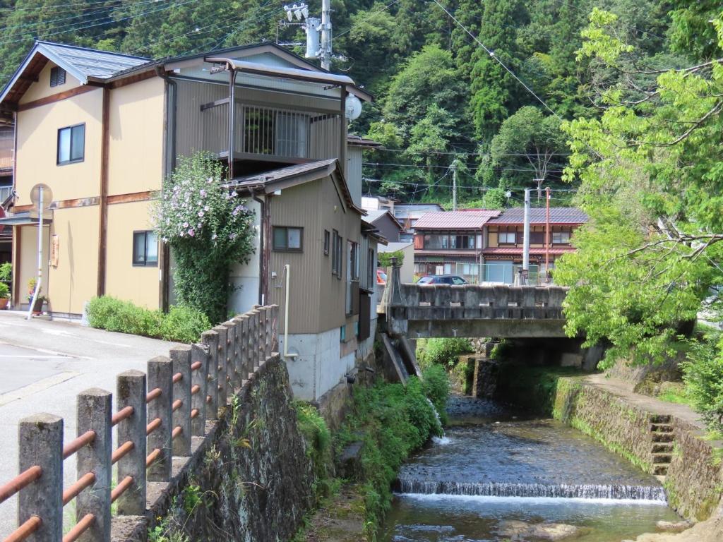 un village avec un pont sur une rivière dans l'établissement SORAMACHI - Vacation STAY 14338, à Takayama